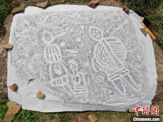 图为考古工作人员在提取岩画群拓片。　刘文举 摄
